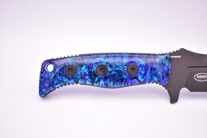 A blue knife with black handle and some blue flowers